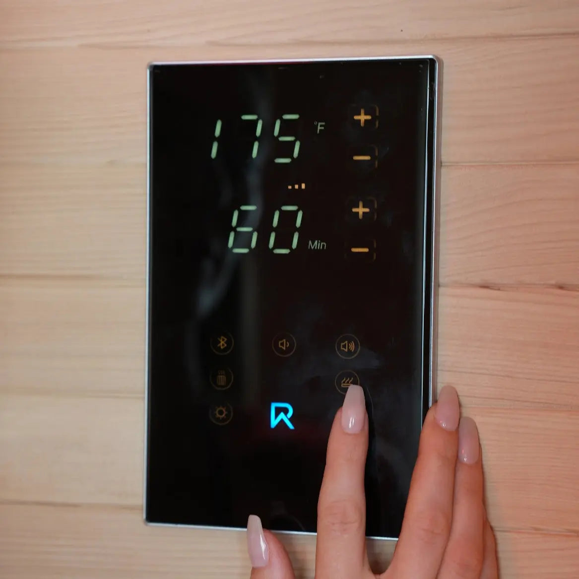Digital timer with a hand adjusting settings on a wooden surface
